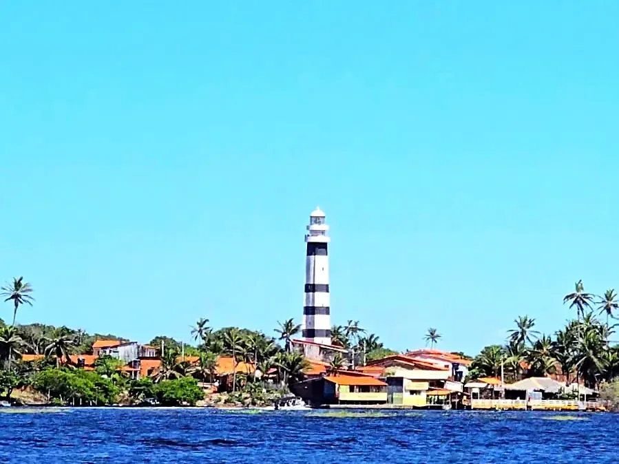 Farol de Mandacaru visto do Rio Preguiças, com a água azul em primeiro plano