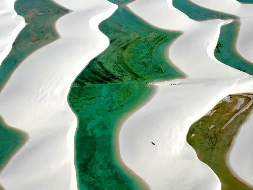 Vista aérea de várias lagoas conectadas em sequência entre as dunas de Santo Amaro