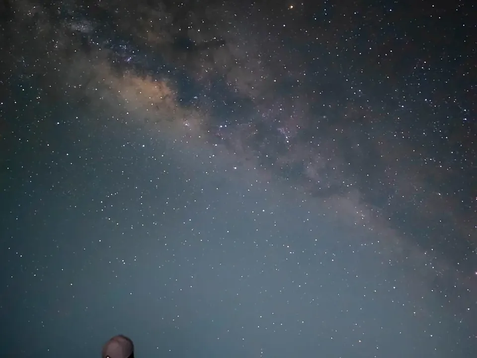 Via Láctea sobre as dunas isoladas de Santo Amaro, com uma pessoa olhando para o céu