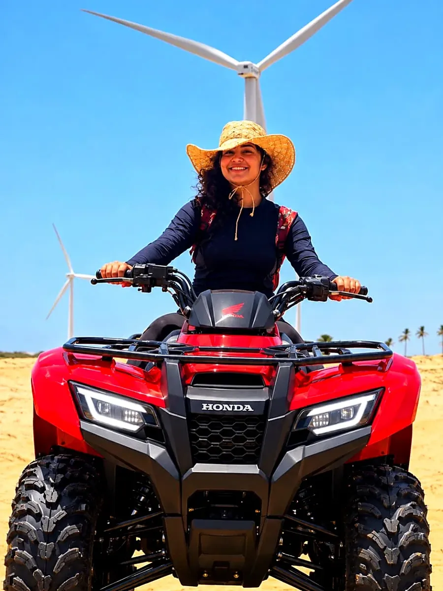Visitante sobre um quadriciclo vermelho na areia dos Pequenos Lençóis